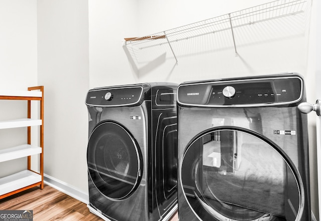 laundry room with hardwood / wood-style floors and washer and clothes dryer