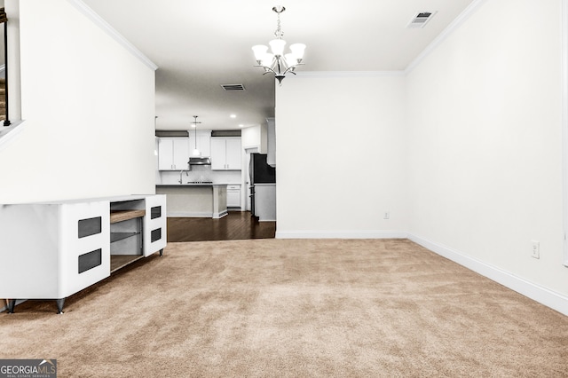 unfurnished living room featuring light carpet, an inviting chandelier, and ornamental molding