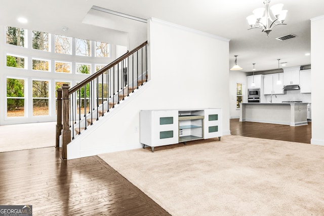 carpeted living room with ornamental molding and a notable chandelier