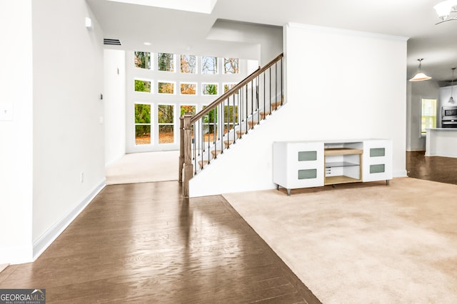 unfurnished living room featuring carpet floors, crown molding, and a chandelier