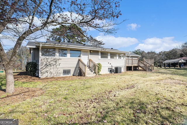 rear view of house with a lawn and a deck