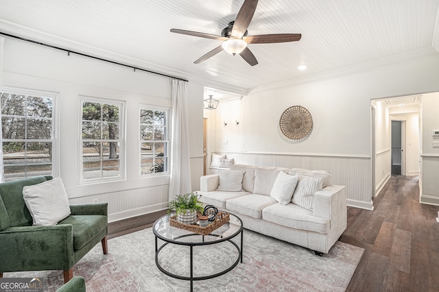 living room with crown molding, ceiling fan, and dark wood-type flooring