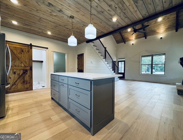 kitchen featuring ceiling fan, hanging light fixtures, a barn door, light hardwood / wood-style floors, and wood ceiling