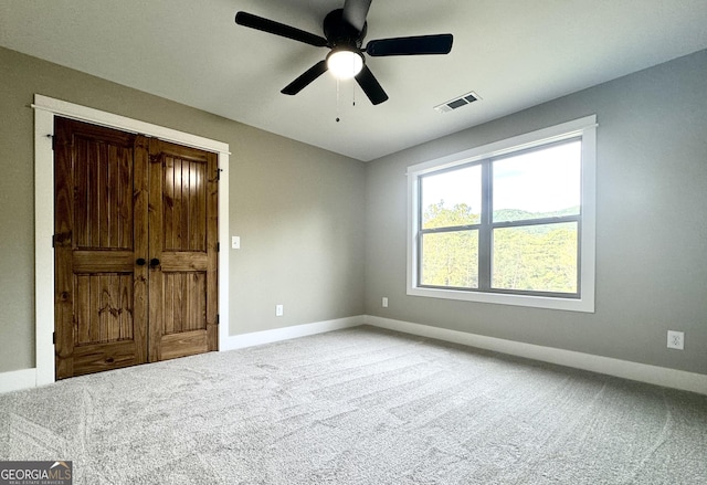 spare room featuring ceiling fan and carpet floors