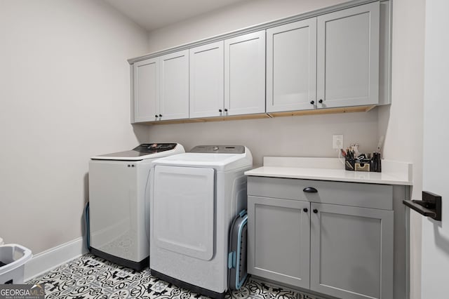 washroom with cabinets, light tile patterned flooring, and washing machine and clothes dryer