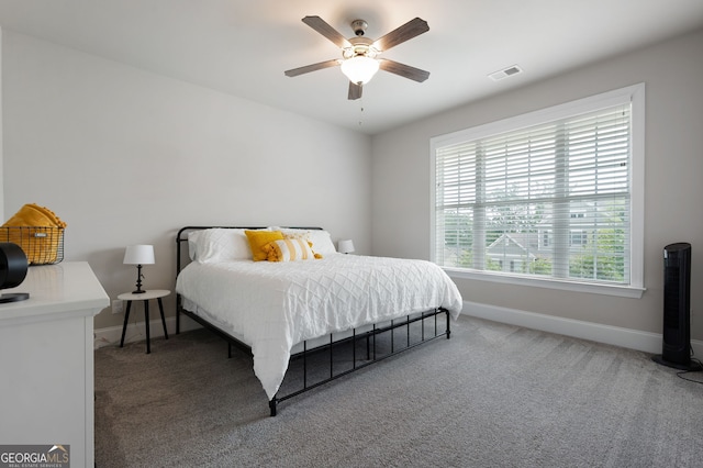 carpeted bedroom with ceiling fan and multiple windows