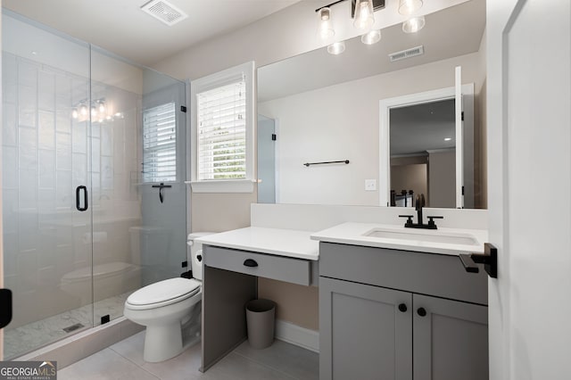 bathroom featuring tile patterned floors, a shower with door, vanity, and toilet