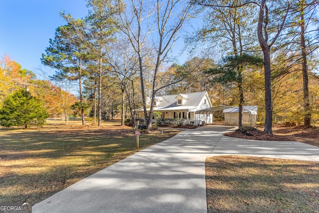 view of front of home with covered porch, a carport, and a front yard