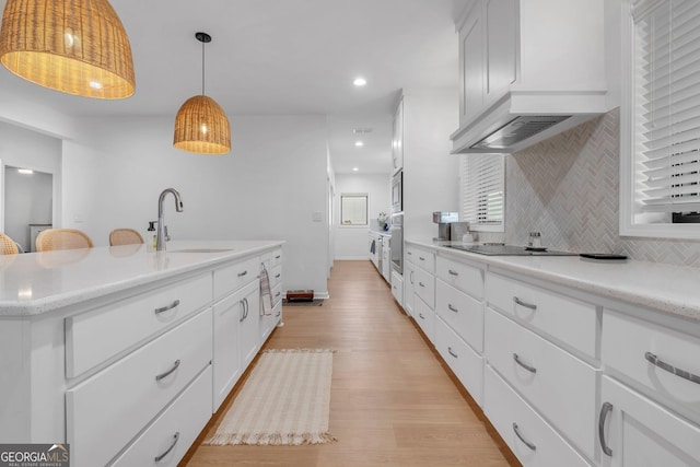 kitchen featuring appliances with stainless steel finishes, tasteful backsplash, sink, decorative light fixtures, and white cabinets