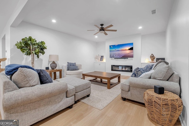 living room featuring light wood-type flooring and ceiling fan