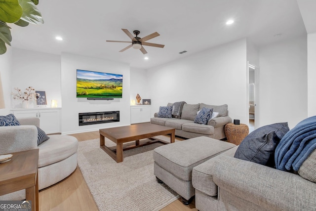 living room featuring light wood-type flooring and ceiling fan