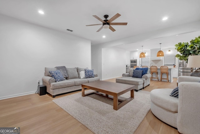 living room featuring ceiling fan and light wood-type flooring