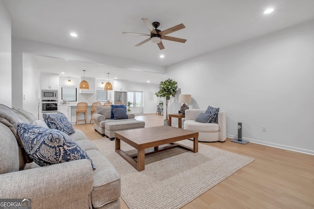 living room featuring ceiling fan and light hardwood / wood-style floors