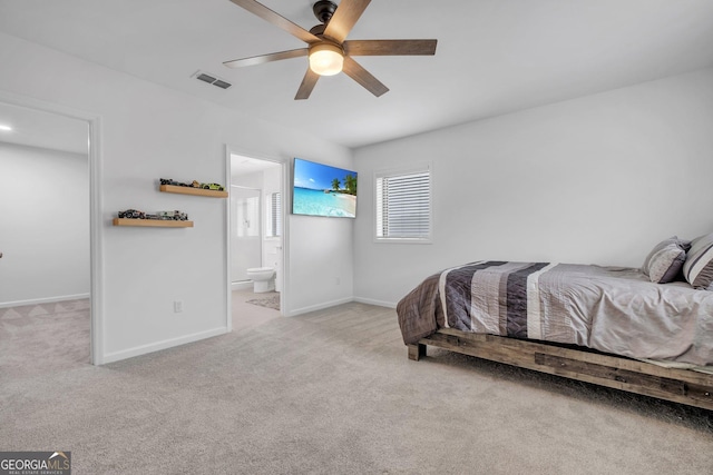 bedroom featuring ceiling fan, light colored carpet, and connected bathroom