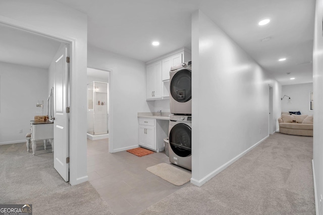 washroom featuring stacked washer / drying machine and light carpet