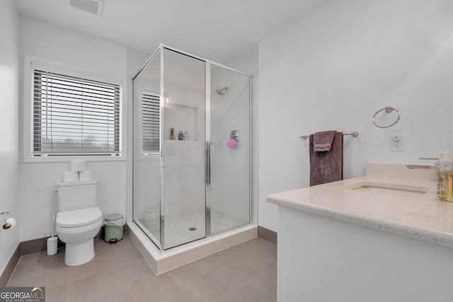 bathroom with tile patterned flooring, vanity, toilet, and an enclosed shower