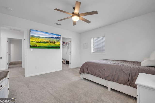 bedroom featuring ceiling fan, light colored carpet, and a spacious closet