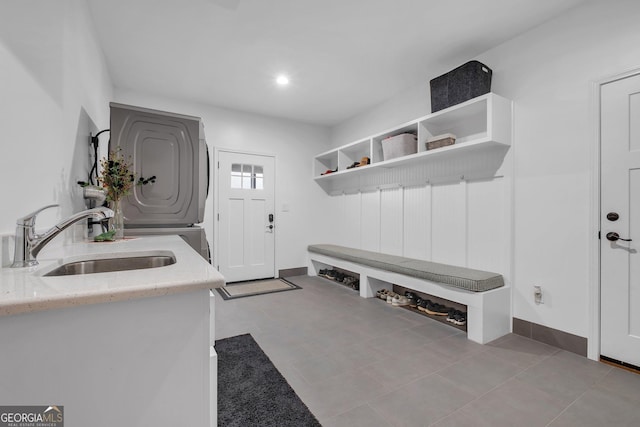 laundry room featuring stacked washing maching and dryer and sink