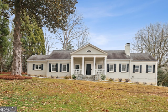 neoclassical home with covered porch and a front yard