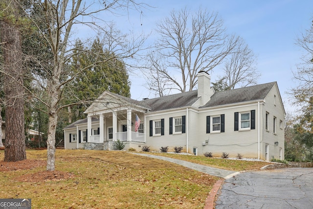 greek revival house featuring a front lawn and a porch