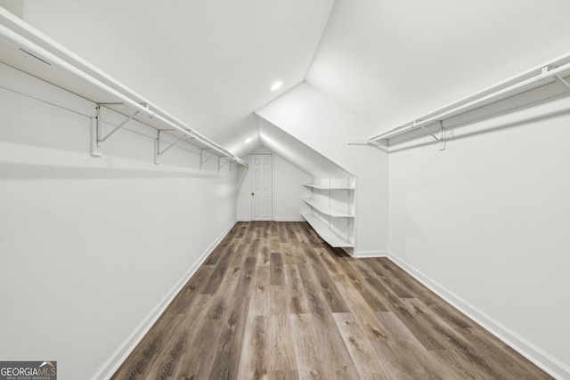 walk in closet featuring wood-type flooring and vaulted ceiling