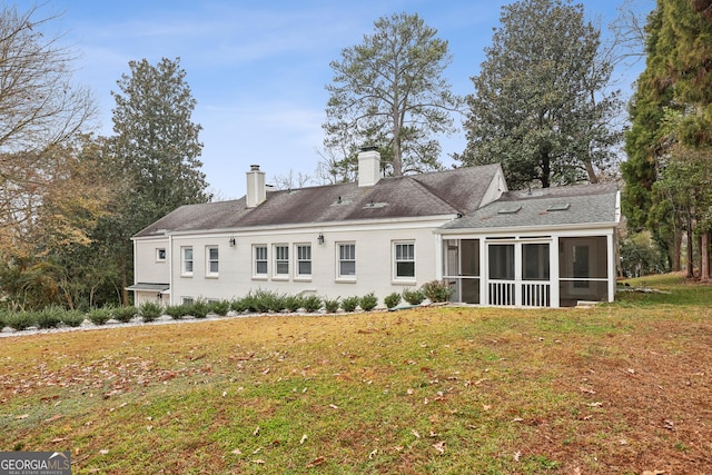 rear view of property featuring a yard and a sunroom