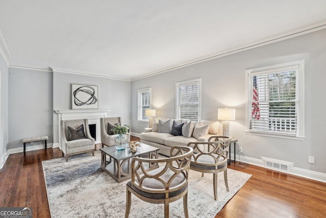 living room with wood-type flooring and ornamental molding