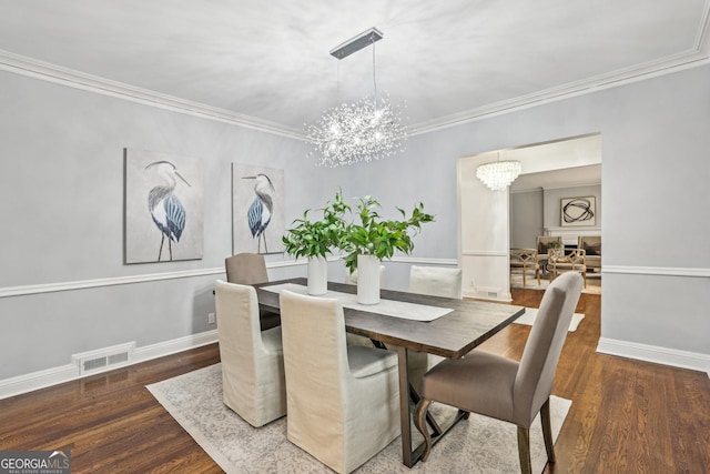 dining space featuring crown molding, dark wood-type flooring, and a chandelier