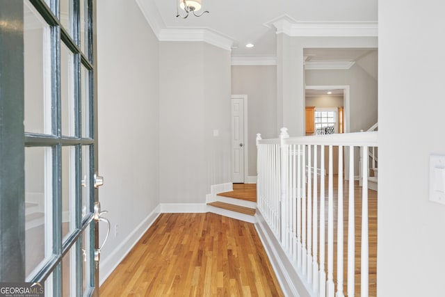 hallway featuring light wood-type flooring and ornamental molding