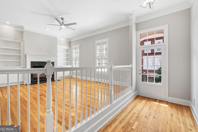 interior space featuring a fireplace, ceiling fan, built in features, and plenty of natural light