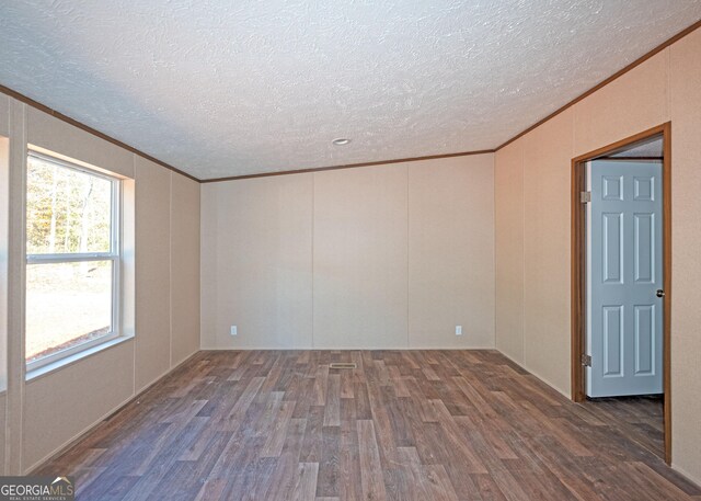 spare room with a textured ceiling, dark hardwood / wood-style floors, and ornamental molding