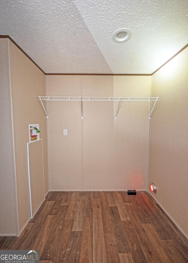 laundry area featuring hookup for a washing machine, dark hardwood / wood-style flooring, a textured ceiling, and ornamental molding