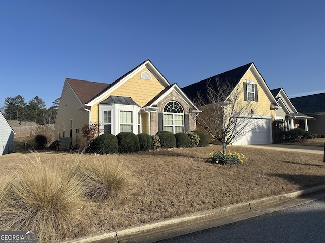 view of front of house featuring an attached garage, brick siding, and driveway