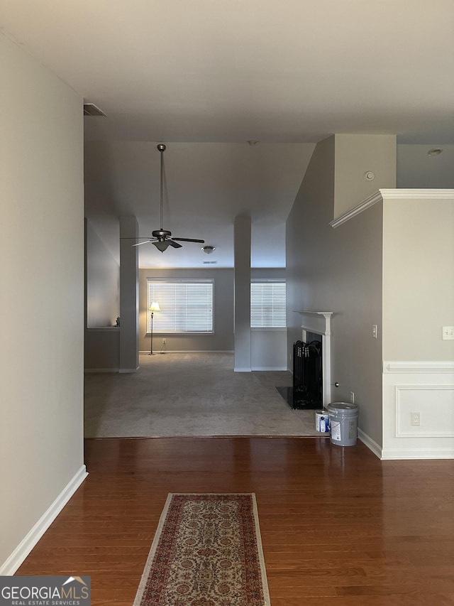 hallway featuring visible vents, wood finished floors, and baseboards