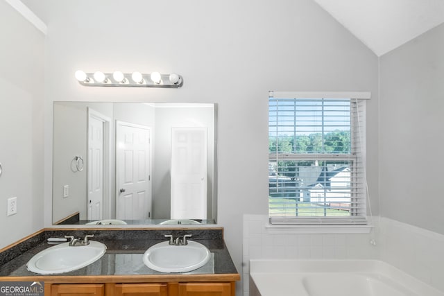 bathroom featuring a bathtub, vanity, and vaulted ceiling