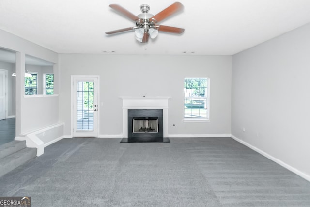 unfurnished living room with dark colored carpet and ceiling fan