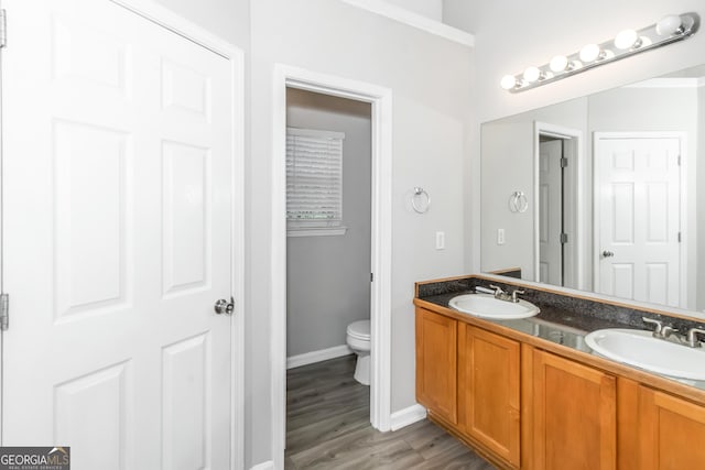 bathroom with hardwood / wood-style flooring, vanity, and toilet