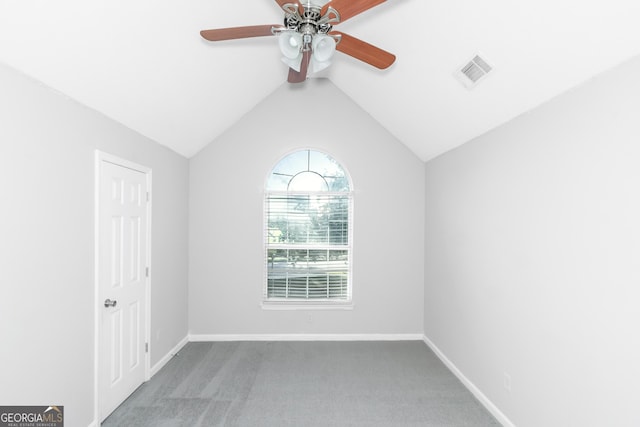 spare room featuring ceiling fan, carpet floors, and vaulted ceiling