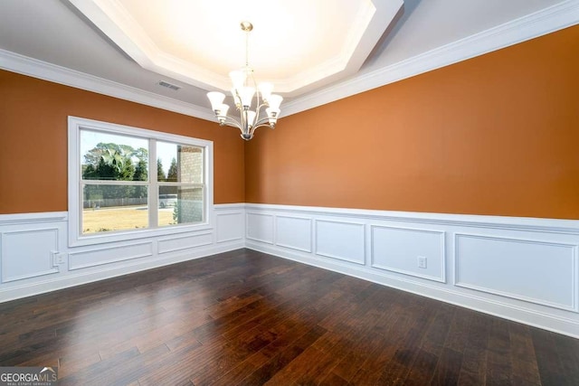 spare room with a wainscoted wall, visible vents, a tray ceiling, dark wood-style flooring, and a notable chandelier