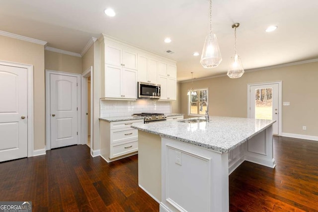 kitchen with dark wood-style floors, white cabinetry, stainless steel microwave, light stone counters, and a sink