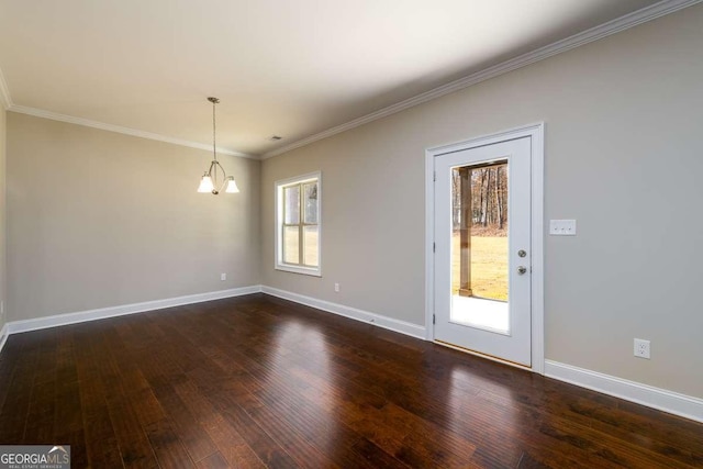 empty room with dark wood-type flooring, baseboards, a chandelier, and ornamental molding