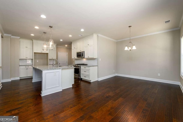 kitchen with a sink, baseboards, stainless steel appliances, and a chandelier
