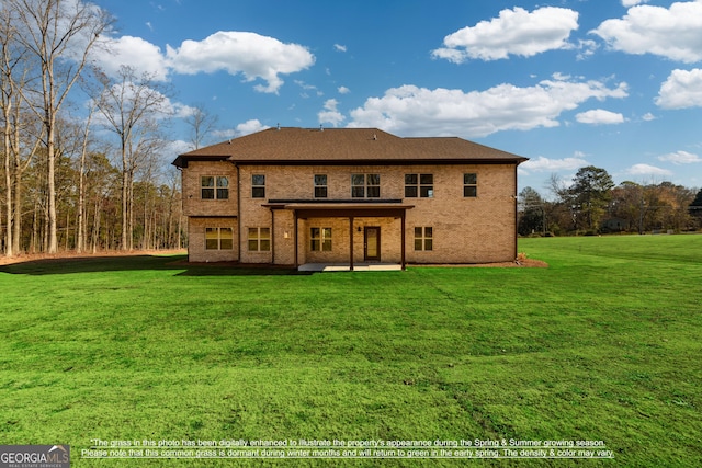 rear view of house featuring a lawn, a patio, and brick siding
