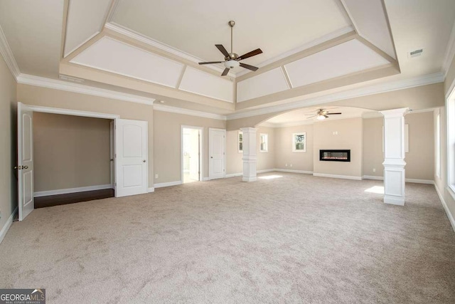 unfurnished living room with carpet floors, a ceiling fan, decorative columns, visible vents, and ornamental molding