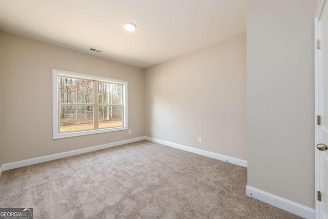 carpeted empty room featuring visible vents and baseboards