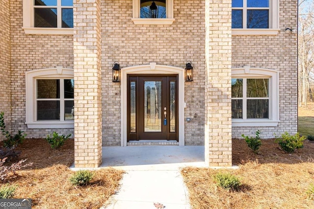 property entrance featuring brick siding