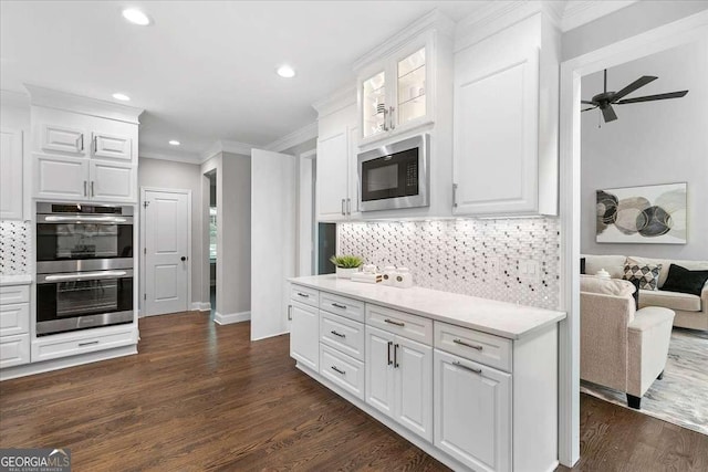 kitchen with white cabinets, double oven, built in microwave, and dark hardwood / wood-style floors