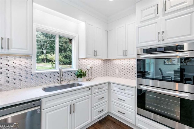 kitchen featuring sink, dark wood-type flooring, decorative backsplash, white cabinets, and appliances with stainless steel finishes