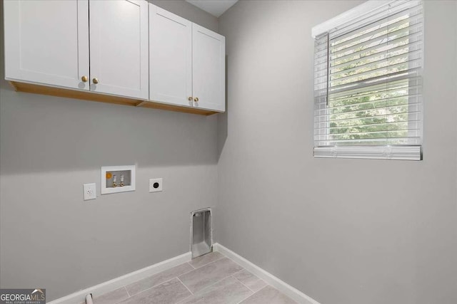 washroom with cabinets, hookup for a washing machine, hookup for an electric dryer, and light tile patterned flooring