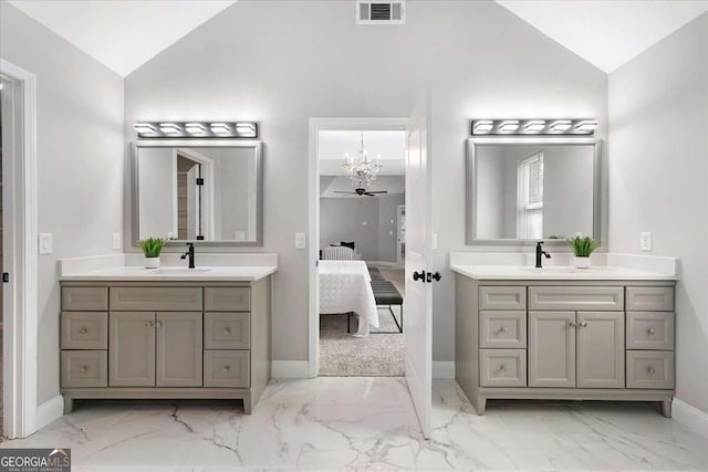 bathroom featuring vanity, ceiling fan with notable chandelier, and lofted ceiling